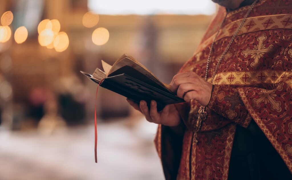 Close-up,Of,An,Orthodox,Priest's,Hands,Holding,The,Bible,During