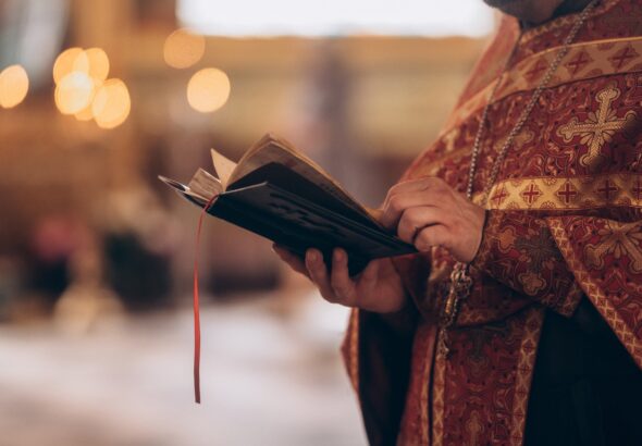 Close-up,Of,An,Orthodox,Priest's,Hands,Holding,The,Bible,During